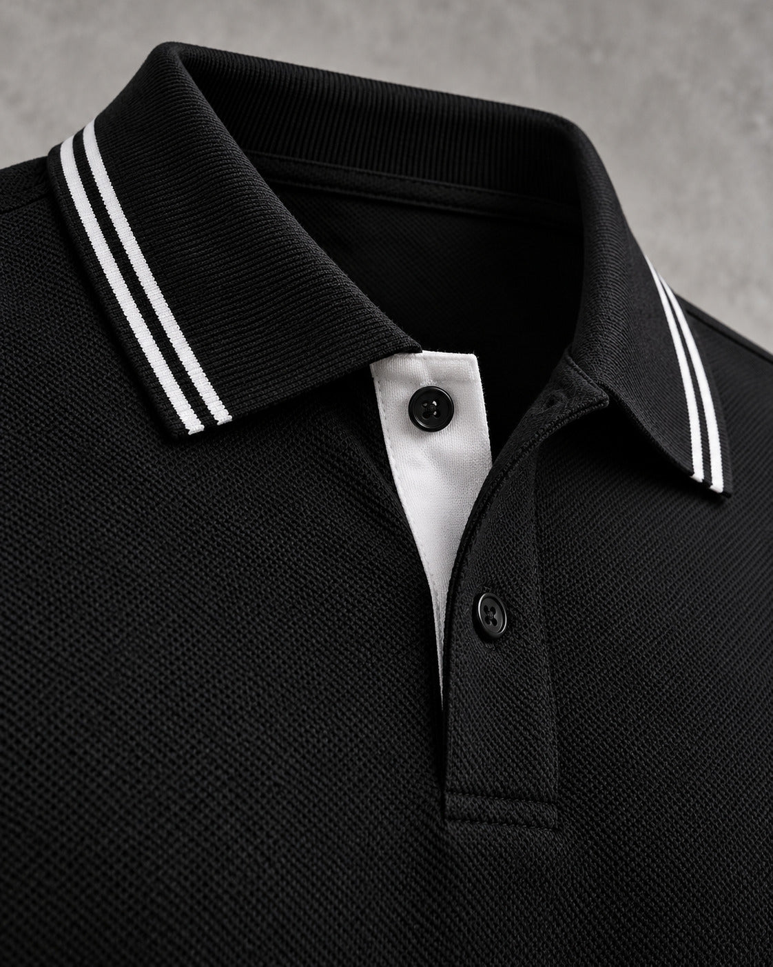 Close-up of a black polo collar with two white tipping stripes.